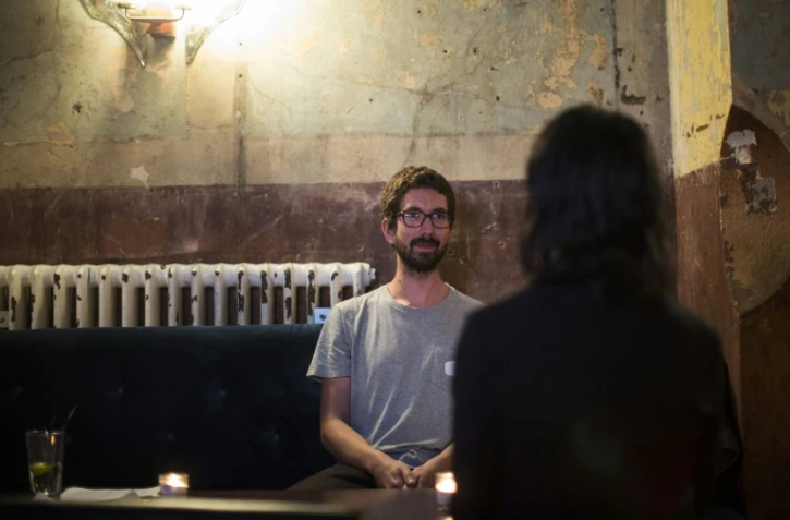 Un homme et une femme lors d'un "shhhh dating", ou rencontre silencieuse dans un bar à l'est de Londres, le 23 septembre 2015