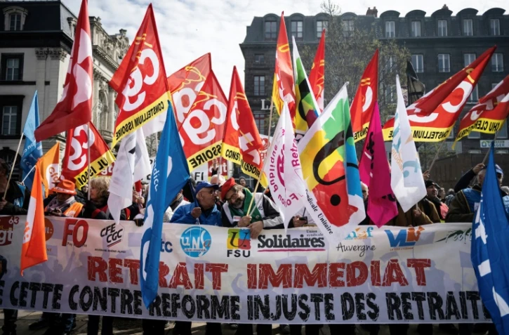 Mobilisation contre la réforme des retraites de manifestants brandissant des drapeaux de syndicats, le 28 mars 2023 à Clermont-Ferrand