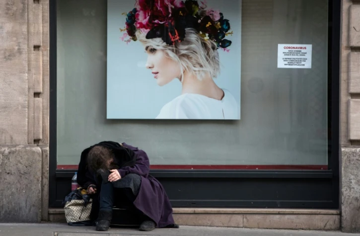 Une personne sans abri devant une boutique fermée pour cause de confinement, le 18 mars 2020 à Paris