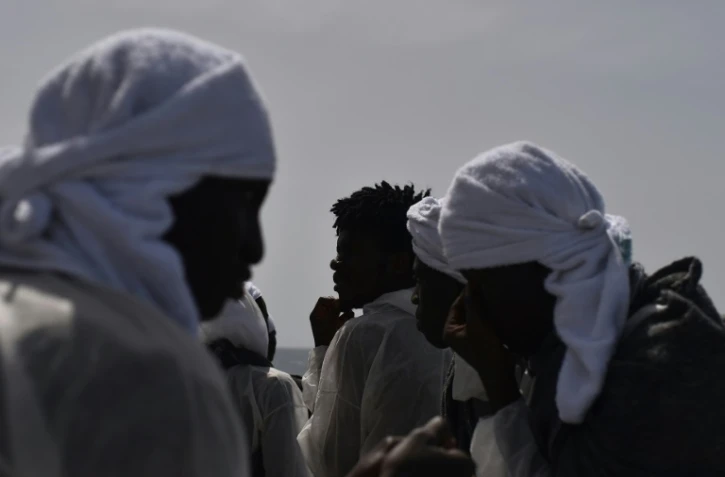 Des migrants regardent la Sardaigne depuis l'Aquarius le bateau qui les a pris en charge, au large des côtes libyennes le 26 mai 2016
