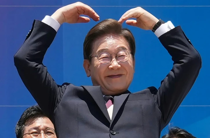 Le président sud-coréen Lee Jae-myung fait fait un cœur avec les bras à l'intention de ses partisans réunis devant l'Assemblée nationale, à Séoul, le 4 juin 2025