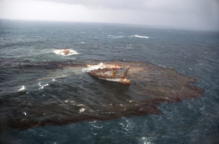 Vue aérienne du pétrolier l'Amoco Cadiz, éventré, qui déverse des centaines de milliers de tonnes de brut au large des côtes bretonnes, le 20 mars 1978 près de Portsall, dans le Finistère