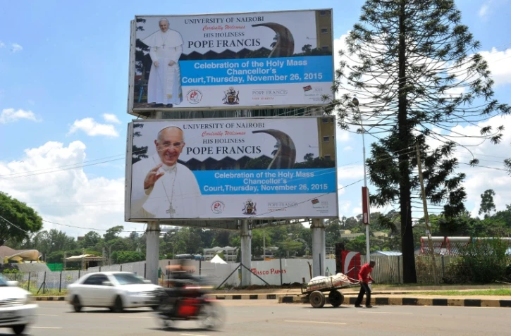 Un homme devant des affiches annonçant la visite du Pape François le 23 novembre 2015 à Nairobi