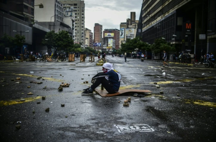 Un opposant à Nicolas Maduro assis dans la rue pendant un blocage le 19 juillet 2017 à Caracas.