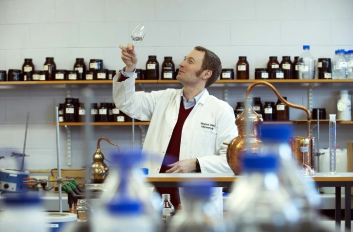 Matthew Pauley professeur au centre international du brassage et de la distillation, examine un whisky dans le laboratoire de l'université  Heriot-Watt à Edimbourg, le 28 février 2018