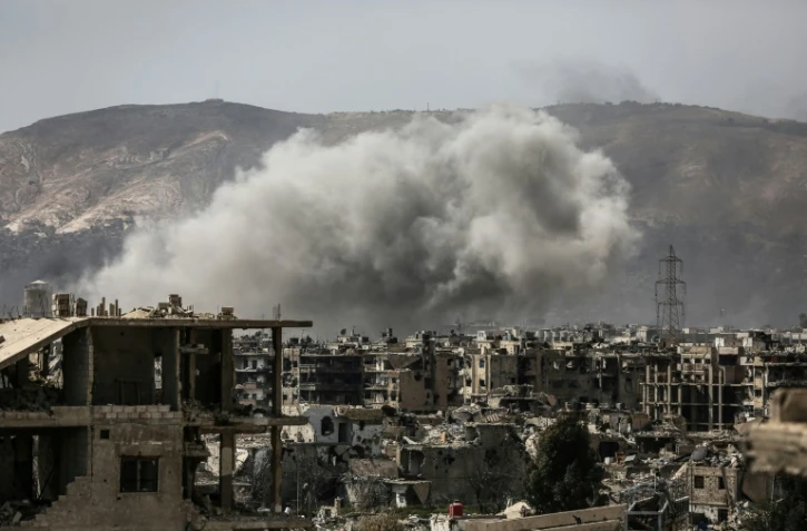 De la fumée au-dessus du quartier de Jobar après une frappe aérienne des forces syriennes contre des positions tenues par les rebelles, le 19 mars 2017 dans la partie est de Damas