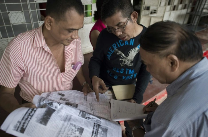 Les partisans d'Aung San Suu Kyi consultent les résultats des élections dans un quotidien le 10 novembre 2015 à Rangoun