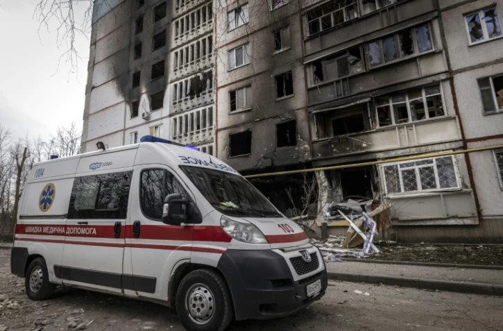 Une ambulance passe devant un bâtiment incendié dans la ville de Kharkiv, dans l'est de l'Ukraine, le 2 avril 2022