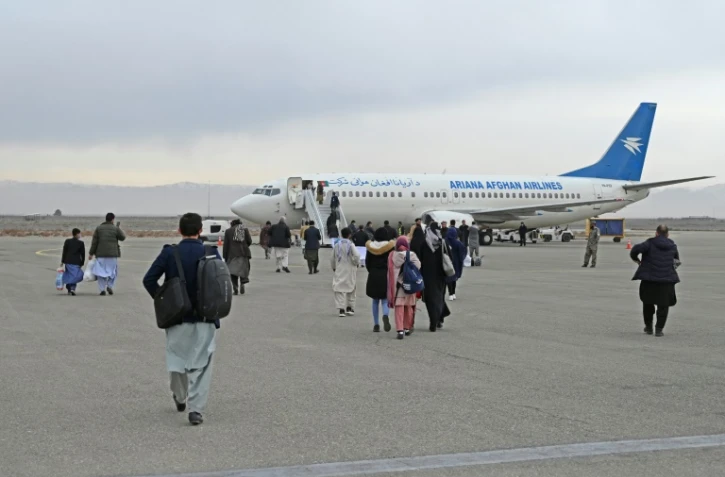 Des passagers embarquent à bord d'un avion de la compagnie Ariana Afghan Airlines à destinationd e Kaboul le 5 février 2022 à Hérat