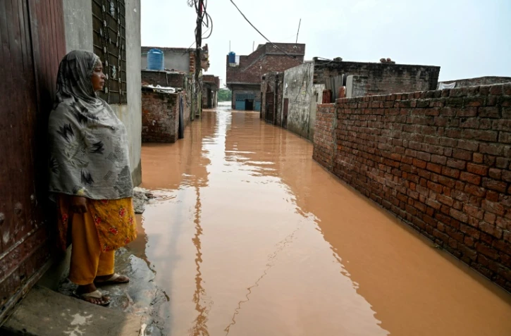 Ghulam Bano près de sa maison submergée par les eaux en crue du fleuve Ravi à Shahdara, le 29 août 2025 au Pakistan