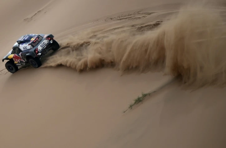 La Mini pilotée par Stéphane Peterhansel fend les dunes du Dakar en direction de Yanbu, en Arabie saoudite, le 14 janvier 2021