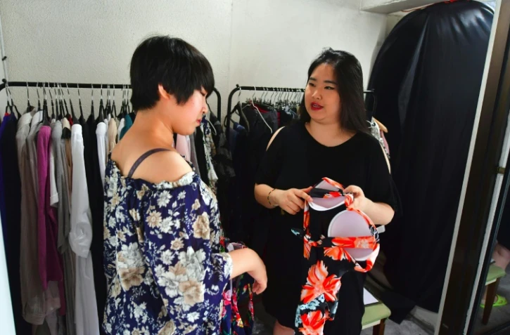 Vivian Geeyang Kim (D) et une cliente le 6 août 2016 dans sa boutique de vêtements à Seoul