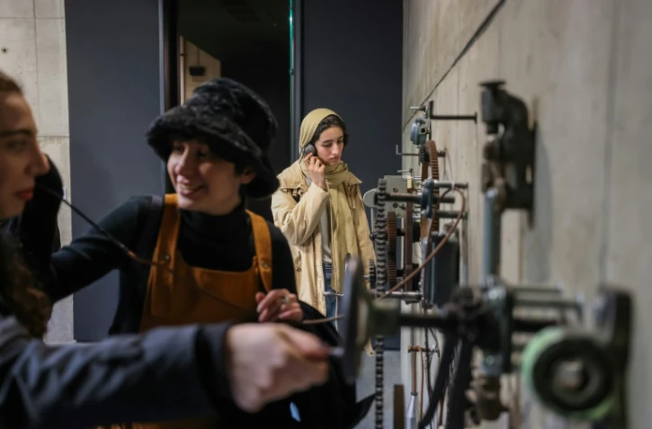 Des visiteurs écoutent de vieux enregistrements dans une exposition à Téhéran, le 4 février 2025