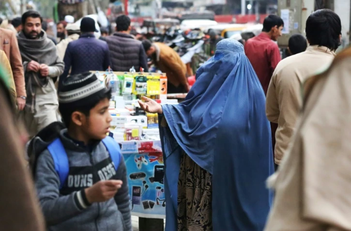 Une femme en burqa fait la manche sur un marché de Jalalabad, en Afghanistan, le 1er février 2023