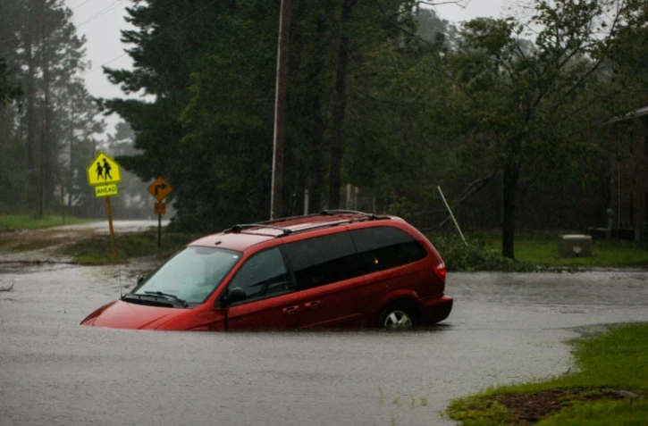 Une voiture abandonnée sur uen route inondée près de New Bern, ville de Caroline du Nord, le 14 septembre 2018 après le passage de l'ouragan Florence sur la côte sud-est américaine 