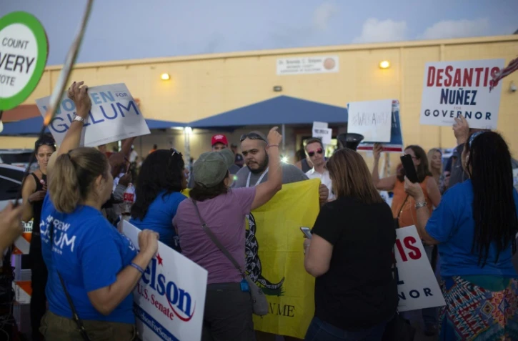 Des partisans des deux principaux candidats au poste de gouverneur de l'Etat de Floride s'invectivent vendredi, dans l'attente des résultats définitifs. Un nouveau décompte a été ordonné samedi.