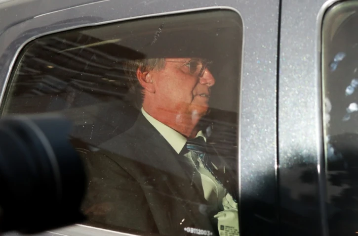 L'ancien président brésilien Jair Bolsonaro en voiture après avoir témoigné au siège de la police fédérale, le 5 avril 2023 à Brasilia