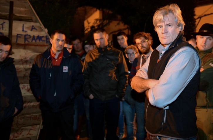 Stéphane Le Foll (d), ministre de l'Agriculture, discute avec des agriculteurs en colère venus manifester devant chez lui au Mans le 21 février 2016