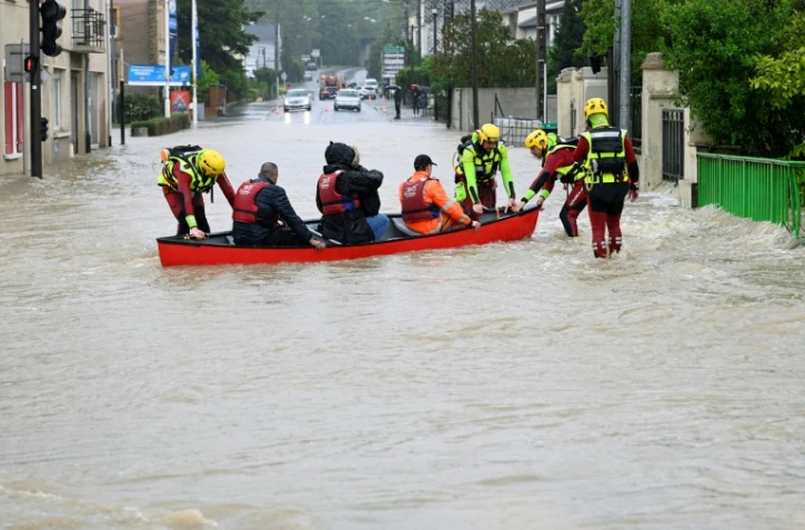 Des habitants sont évacués par les pompiers dans une barque, le 17 mai 2024 à Bouzonville, en Moselle