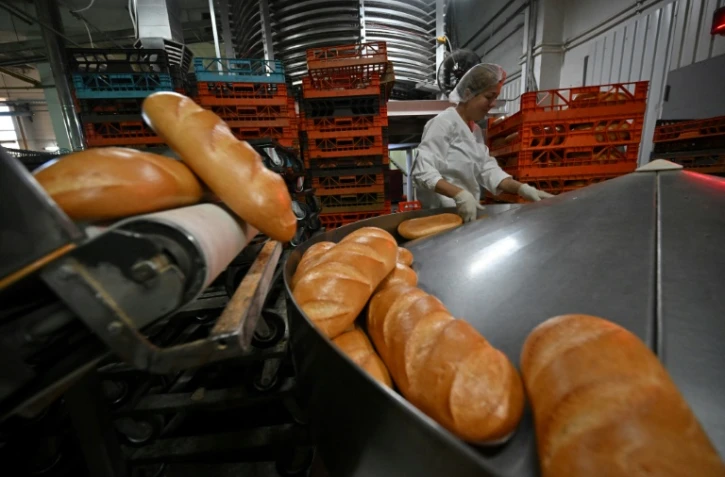 Une employée de l'usine de pain Tsar-Khlib près de Kiev vérifie la qualité des miches le 25 mai 2022