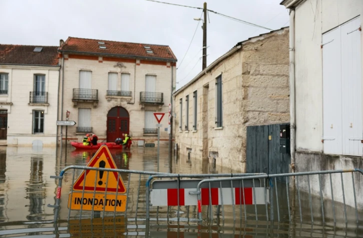 Des sauveteurs en barque dans une rue inondée après la crue de la Charente à Saintes, le 18 février 2026 en Charente-Maritime