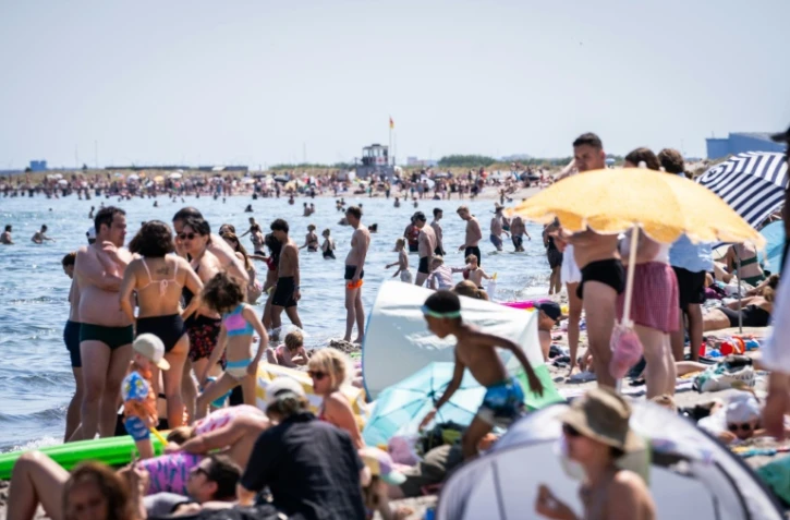 Des centaines de personnes essaient de se rafraîchir sur la plage d'Amager à Copenhague, le 27 juin 2026