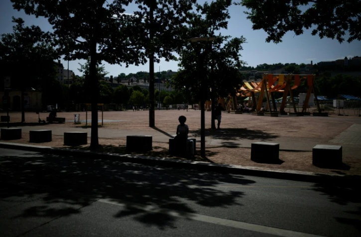 Une personne est assise à l'ombre d'arbres à Lyon, le 25 juin 2025