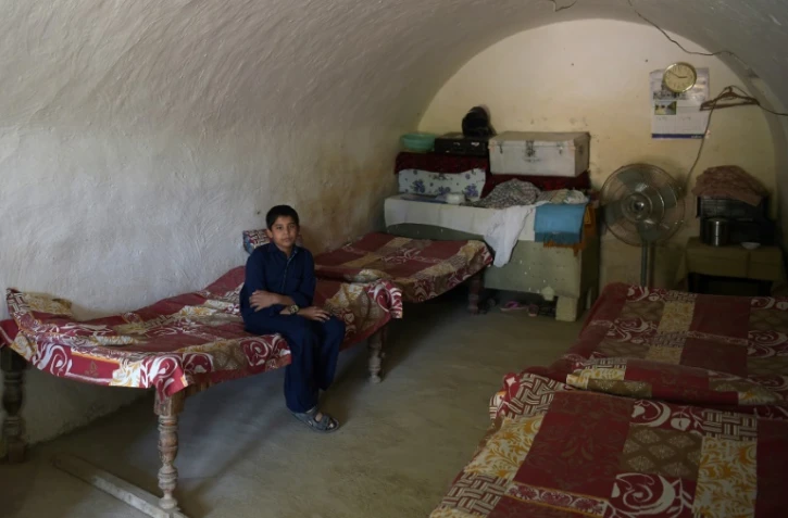 Un jeune Pakistanais dans une pièce de son logement troglodytique, dans le village de Hsan Abdal, le 6 octobre 2018 au Pakistan, à 60 km d'Islamabad