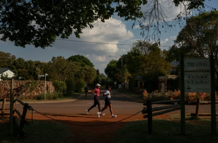 Nancy Masha (D) et Babalwa Melitafa (G) font leur jogging dans un lotissement sécurisé à Irene, près de Pretoria, en Afrique du Sud, le 21 septembre 2026