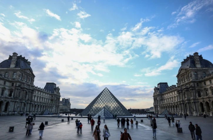Des touristes près de la pyramide du Louvre, conçue par l'architecte sino-américain Ieoh Ming Pei, le 28 février 2025