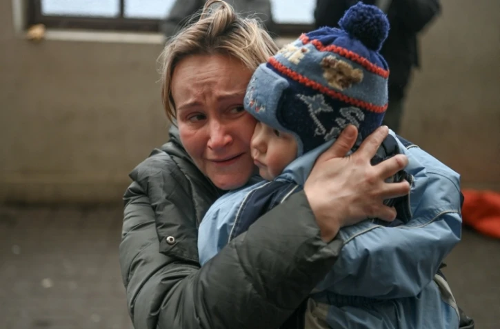Une femme serre son enfant alors qu'elle tente de monter à bord d'un train au départ de Lviv, dans l'ouest de l'Ukraine, en direction de la Pologne, le 3 mars 2022