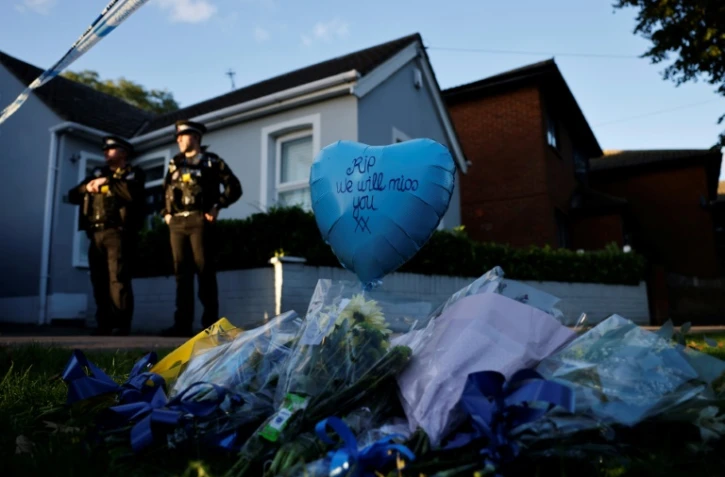 Des hommages sont placés près du lieu de l'aggression à l'arme blanche, tandis que des officiers de police montent la garde près de l'église méthodiste de Belfairs à Leigh-on-Sea, dans le sud-est de l'Angleterre, le 15 octobre 2021