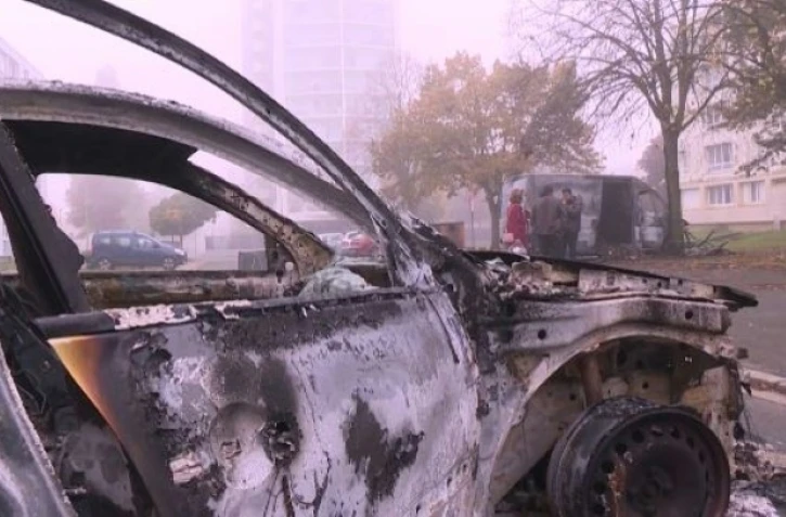 Image tirée d'une vidéo de l'AFPTV montrant un véhicule brûlé dans un quartier d'Alençon après une nuit de violences urbaines, le 27 octobre 2021