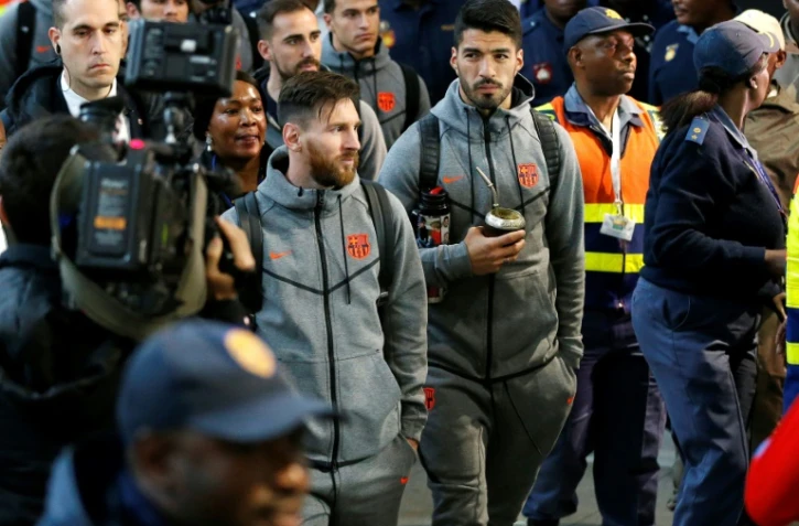 Les joueurs du FC Barcelone Lionel Messi (G) et Luis Suarez (D) arrivent à l'aéroport de Johannesburg, le 16 mai 2018