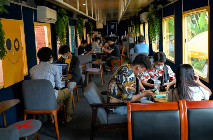 Des personnes attablées dans un wagon de train reconverti en café, le 5 juin 2021 à Phnom Penh, au Cambodge