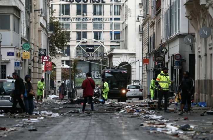 Des employés municipaux nettoient une rue jonchée de débris au lendemain d'une manifestation contre la vie chère, le 18 octobre 2026 à Marseille
