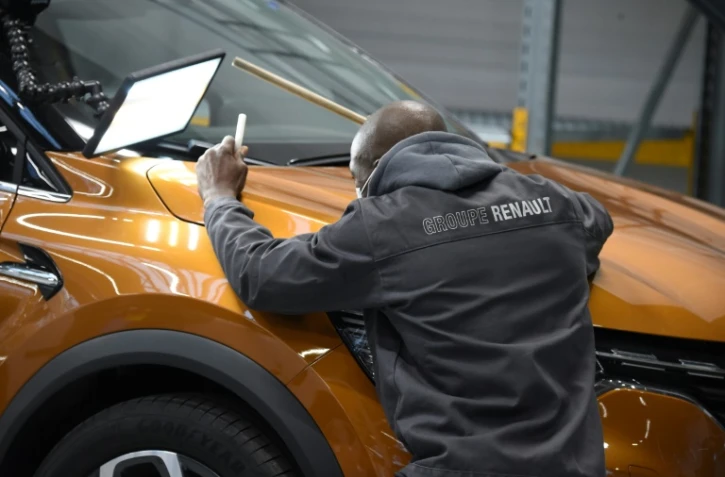 Un employé examine une voiture dans l'usine ReFactory de Flins-sur-Seine, dans les Yvelines, le 30 novembre 2021