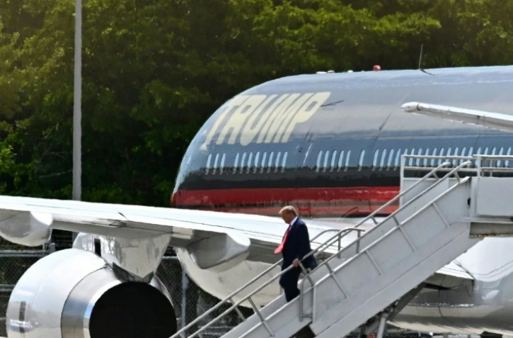 L'ancien président américain Donald Trump descend de son avion privé "Air Trump One" à son arrivée à l'aéroport de Miami, le 12 juin 2023
