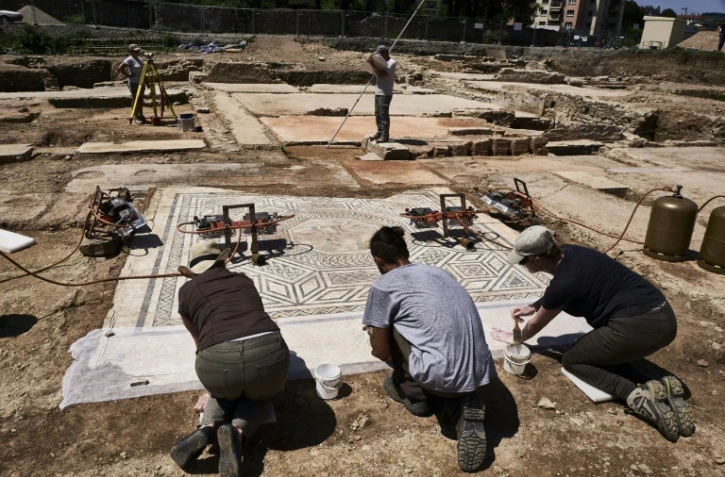 Des archéologues travaillent sur une mosaïque après la découverte d'un faubourg entier de la Vienne romaine, le 31 juillet 2017 à Sainte-Colombe, dans le Rhône