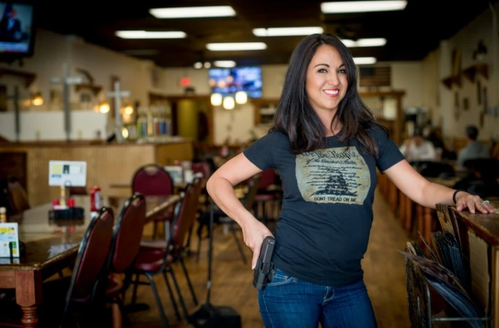 Lauren Boebert, patronne du restaurant "Shooters Grill" à Rifle dans le Colorado (ouest), pose avec une arme à la ceinture dans son établissement, qui accepte aussi les clients armés, le 24 avril 24 2018