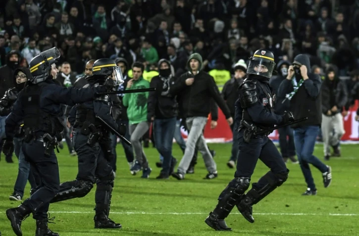 Les forces de sécurité tentent de disperser des supporters ayant envahi la pelouse de Geoffroy-Guichard lors du derby Saint-Etienne-Lyon, le 5 novembre 2017