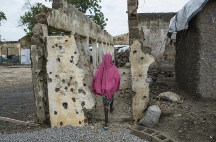 Une fille marche sur un site bombardé à Rann près de la frontière camerounaise le 29 juillet 2017
