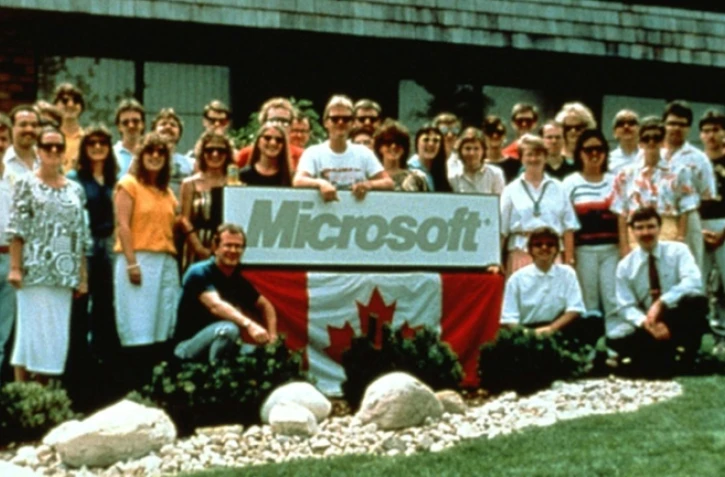 Photo fournie par Microsoft montrant des employés de Microsoft Canada devant le siège du groupe à Toronto, le 28 février 1988 avec Malcom MacTavish (c), alors patron de la branche