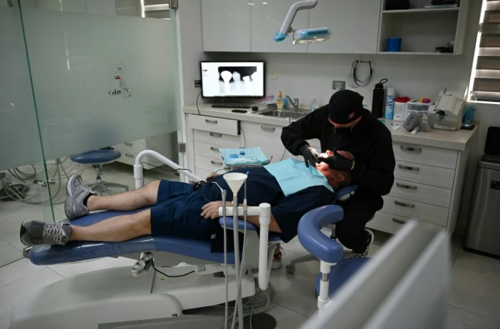 Un dentiste pose des implants dentaires sur un patient américain au cabinet Rubio Dental Group, à Los Algodones, le 11 avril 2023 au Mexique