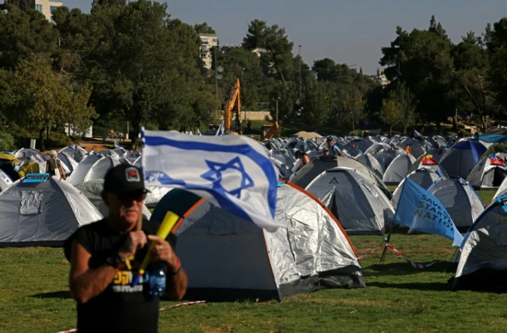 Des manifestants opposés à la réforme judiciaire montent leurs tentes devant le Parlement et la Cour suprême à Jérusalem, le 23 juillet 2023