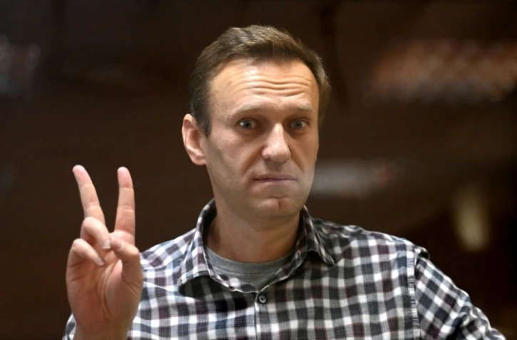 L'opposant russe Alexeï Navalny fait le signe de la victoire depuis son box vitré durant une audience du tribunal de Babouchkinski à Moscou, le 20 février 2021
