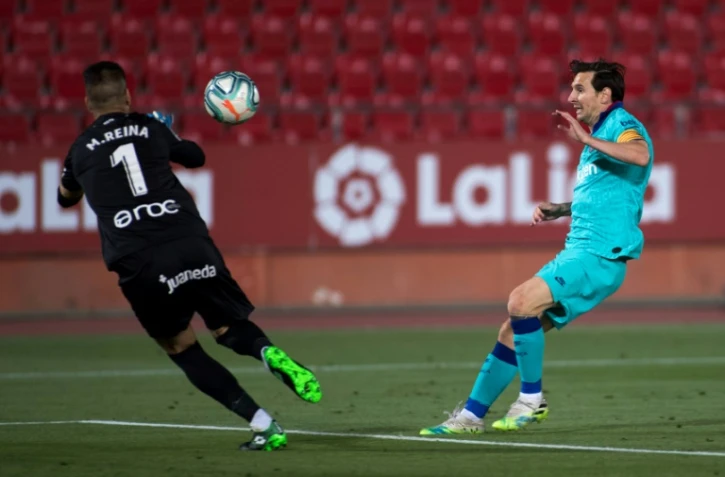 L'attaquant argentin de Barcelone, Lionel Messi (d), défie le gardien espagnol de Majorque, Manolo Reina, lors du match de Liga à Palma de Majorque, le 13 juin 2020