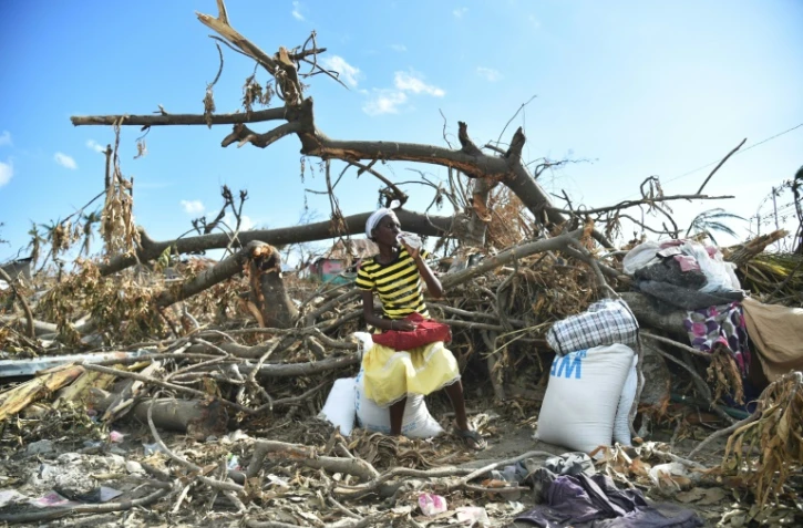 Une Haïtienne, victime de l'ouragan Matthew, vient de recevoir des rations alimentaires de l'aide humanitaire, à Roche-a-Bateaux, le 12 octobre 2016 dans les Cayes  