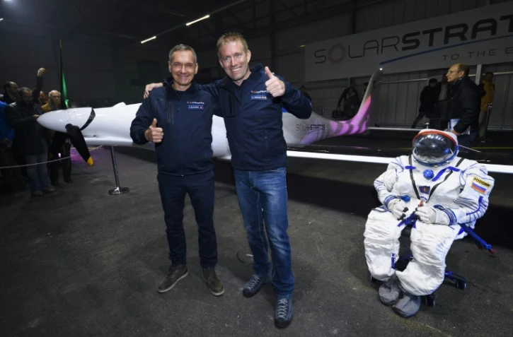 L'aventurier suisse Raphael Domjan (d) et le pilote suisse Thierry Plojoux, devant une combinaison de vol et le SolarStratos à Payerne le 7 décembre 2016