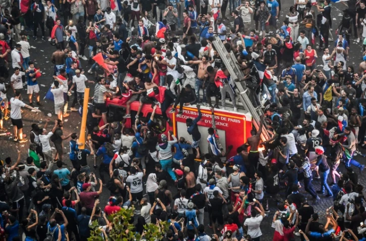 Un camion de pompiers pris d'assaut par des supporters en liesse après le succès de la France en finale du Mondial, le 15 juillet 2018 sur les Champs-Elysées 